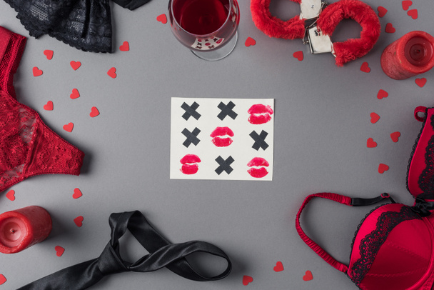 Top uitzicht van Tic-tac-toe spel tussen ondergoed en glas wijn, Valentijnsdag concept  - Foto, afbeelding