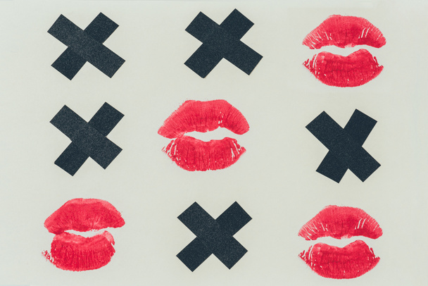 bovenaanzicht van Tic-tac-toe met zwarte kruisen en lippen prints geïsoleerd op wit, Valentines Day concept - Foto, afbeelding