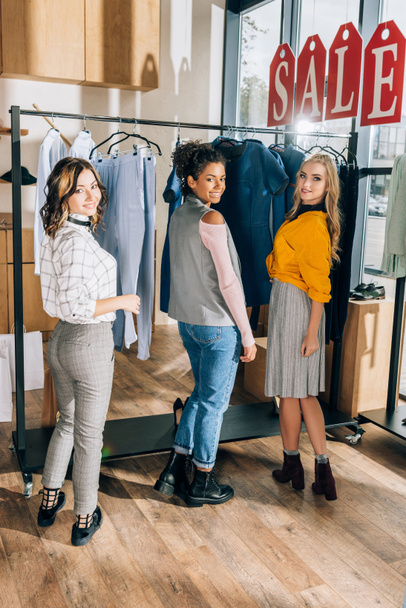 группа молодых женщин по шопингу в магазине одежды
 - Фото, изображение