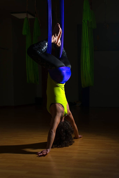 hübsche Mädchen übt Anti-Schwerkraft-Yoga-Position in der Turnhalle auf einem blu - Foto, Bild