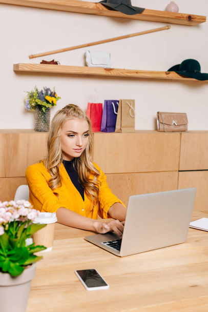 clothing store manager working with laptop at workplace - Фото, зображення