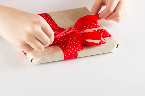 Hand holding ribbon and open gift box - Фото, изображение