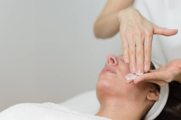 Kozmetikus krém elkészítése, vonatkozik a kliens női arc peeling és bőrradír maszk kezelés után.  - Fotó, kép