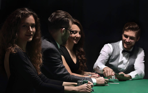 players sitting at the playing table in the casino - Foto, Imagen