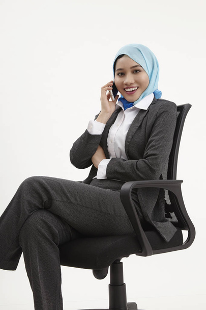 malay business woman sitting on office chair talking using mobile phone - Fotografie, Obrázek