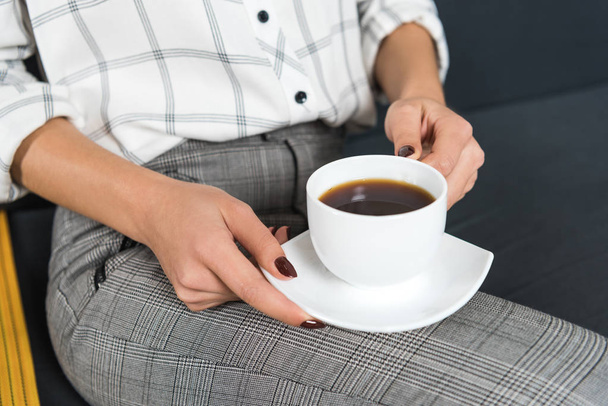 oříznutý snímek ženy s šálkem kávy v ruce - Fotografie, Obrázek