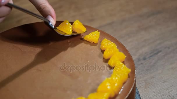 Naisten käsin koristeltu suklaa mousse kakku oranssi segmentit
 - Materiaali, video