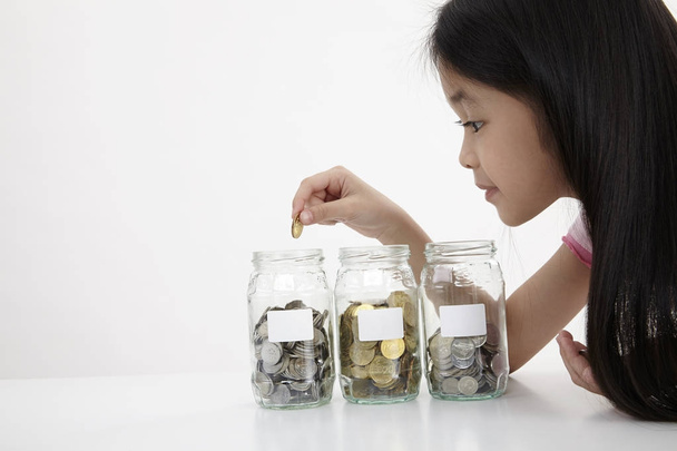 little with three saving jars with coins - Фото, зображення