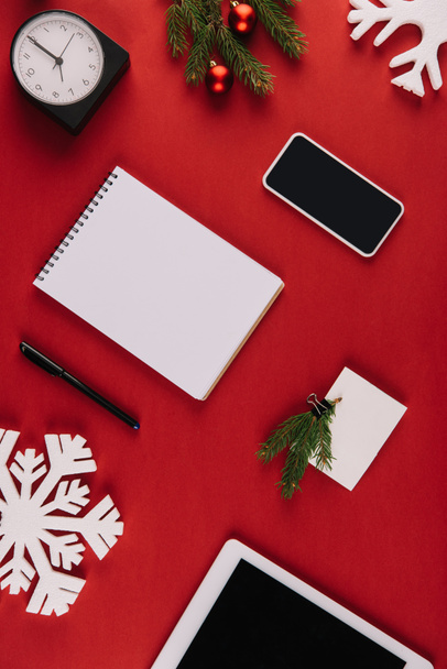 piso con suministros de oficina, copo de nieve decorativo y juguetes de Navidad aislados en rojo
 - Foto, Imagen