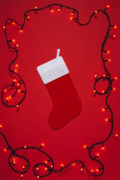 flat lay with empty christmas sock and lights isolate don red - Foto, Imagem