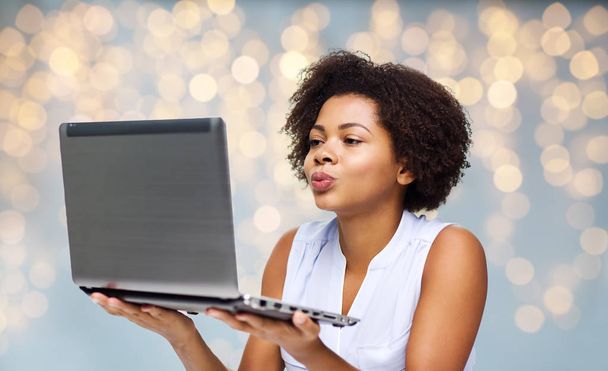 woman with laptop computer sending kiss to someone - Photo, Image
