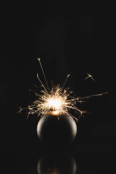 close up view of burning sparklers in christmas toy isolated on black - Фото, изображение