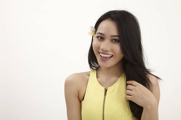 malay woman with yellow frangipani flower on her ear - Foto, Imagen