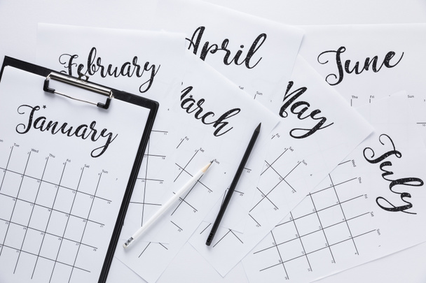 flat lay with calendar, notepad and pencils isolated on white - Foto, Imagem