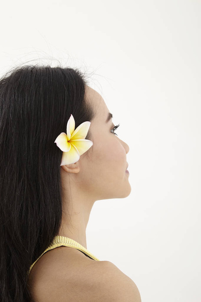 malay woman with yellow frangipani flower on her ear - Foto, imagen