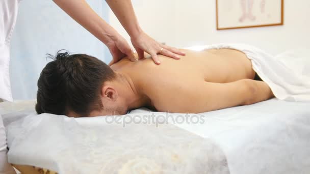 El médico hace masaje espalda y hombros al hombre en la fisioterapia
 - Metraje, vídeo
