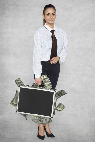 Businesswoman with a suitcase stuffed from bribes - Foto, imagen
