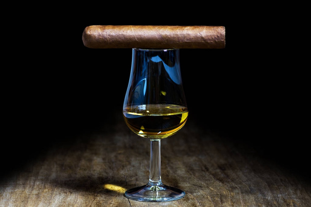 Un vaso de whisky con un cigarro
 - Foto, imagen