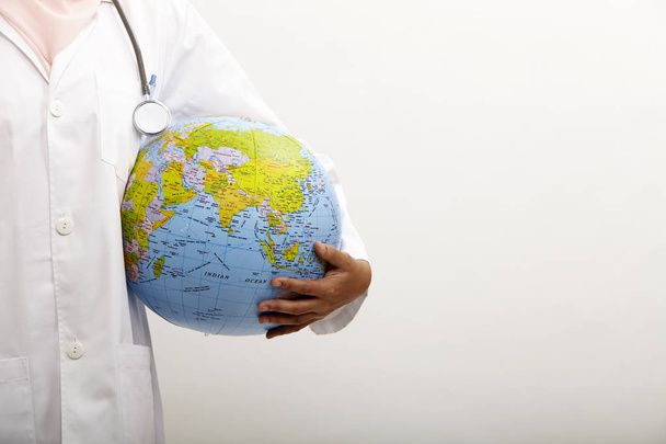 malay female doctor holding globe on the white background - Foto, Imagem
