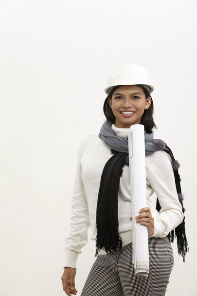 young female architect holding blue print on the white background - Foto, afbeelding
