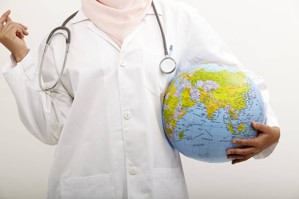 malay female doctor holding globe on the white background - Photo, image