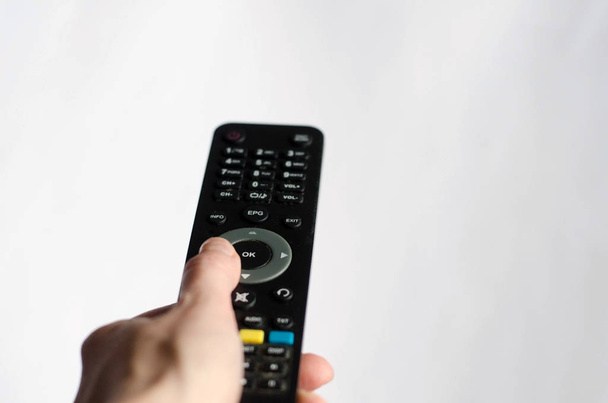 A hand holding a remote control for the television - Photo, Image