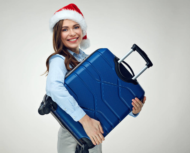Seyahat bavul tutan Noel şapka giyen neşeli kadın  - Fotoğraf, Görsel