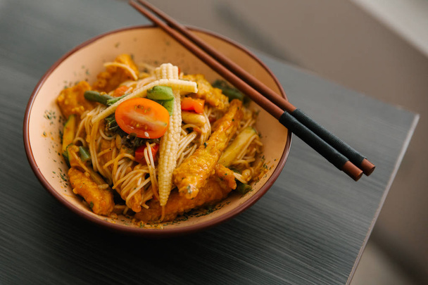 Μπολ ιαπωνική παραδοσιακή σαλάτα με noodles, baby καλαμπόκι, τομάτες, ψάρια στη σχάρα και μπαχαρικά - Φωτογραφία, εικόνα