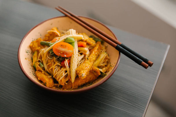 Μπολ ιαπωνική παραδοσιακή σαλάτα με noodles, baby καλαμπόκι, τομάτες, ψάρια στη σχάρα και μπαχαρικά - Φωτογραφία, εικόνα