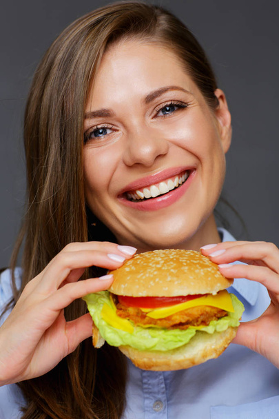 portrait of young smiling woman eating fast food burger  - Фото, изображение