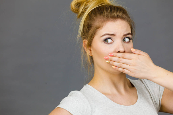 Woman covering her mouth with hand - 写真・画像