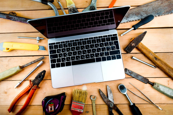 Computer and old tools on a wooden natural background. - Photo, Image