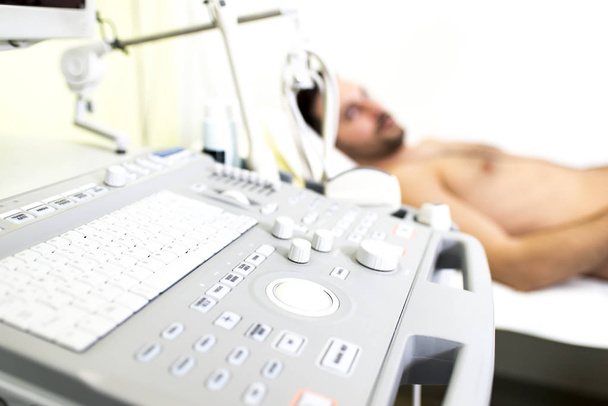 Paciente masculino joven en el examen de ultrasonido
 - Foto, Imagen