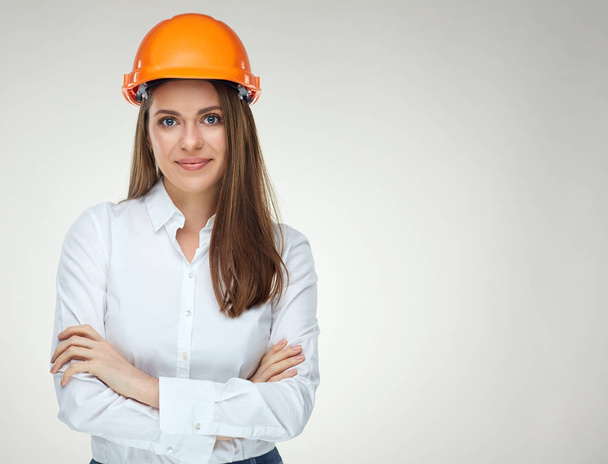 smiling confident woman builder architect in white shirt and protective helmet standing with crossed arms  - Фото, зображення