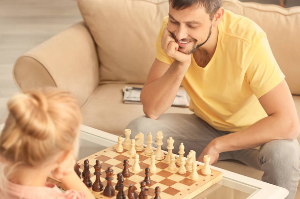 Cute girl playing chess with her father at home - Foto, Imagem