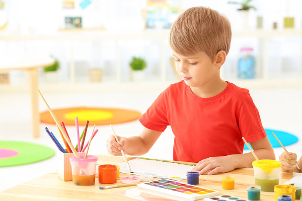 Cute boy painting picture at table indoors - Photo, image