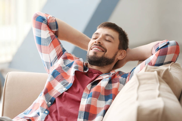 Handsome man relaxing on sofa at home - Photo, image