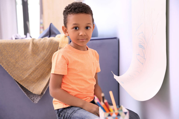 Little African-American boy drawing on paper roller indoors - Zdjęcie, obraz