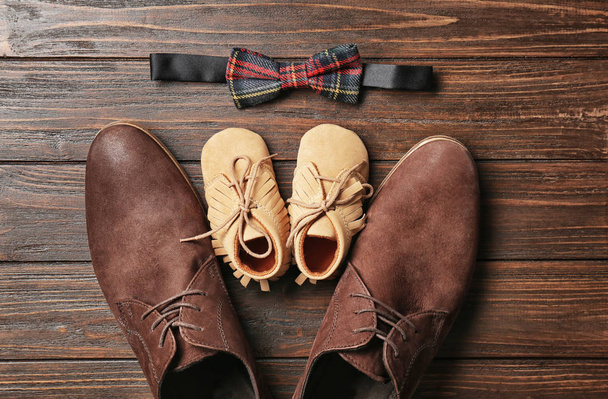 Bow tie, big and small shoes on wooden background. Father's day composition - Foto, Imagem