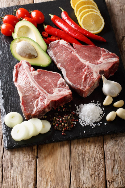 Organic raw t-bone beef steak with ingredients close-up. vertica - Photo, image