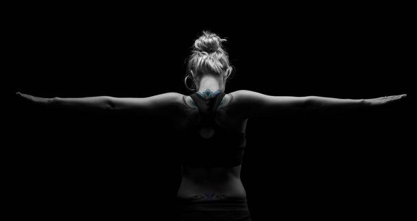 Beautiful fit and healthy blond woman in black top in dark with  - Fotó, kép