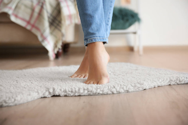 Woman standing on soft white carpet at home - Foto, Bild