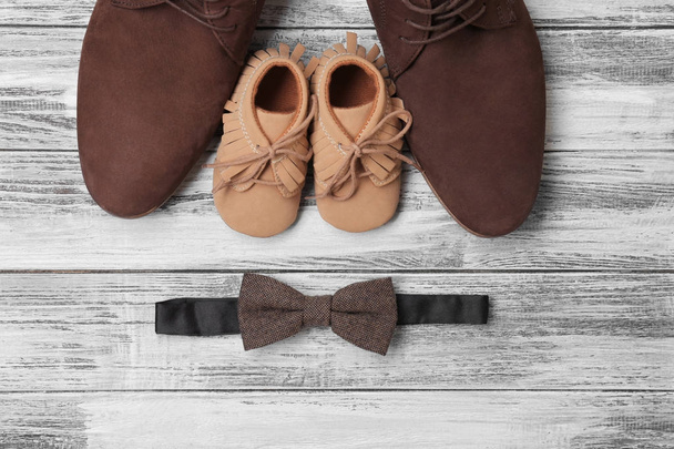 Bow tie, big and small shoes on wooden background. Father's day composition - Foto, Bild