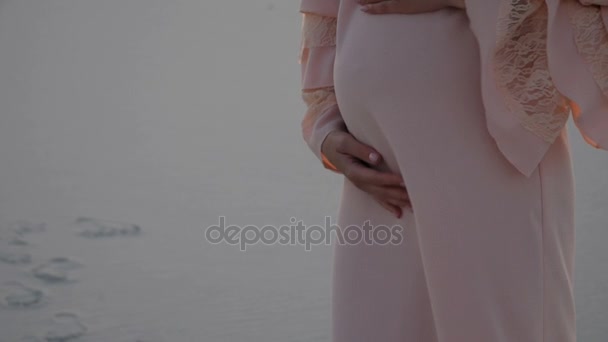 Mamma mette le mani sulla pancia incinta. Coppia incinta accarezzando pancia incinta
. - Filmati, video