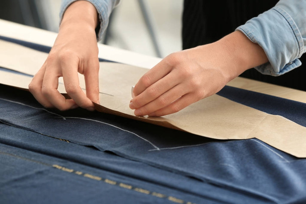Young tailor working with sewing pattern, closeup - Zdjęcie, obraz