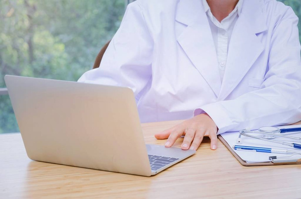doctor working with laptop computer, clipboard and stethoscope on desk in hospital,laboratory research, science, chemical, health care and medical technology concept  - Photo, Image