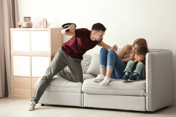 Homme menaçant son fils et sa femme à la maison
 - Photo, image