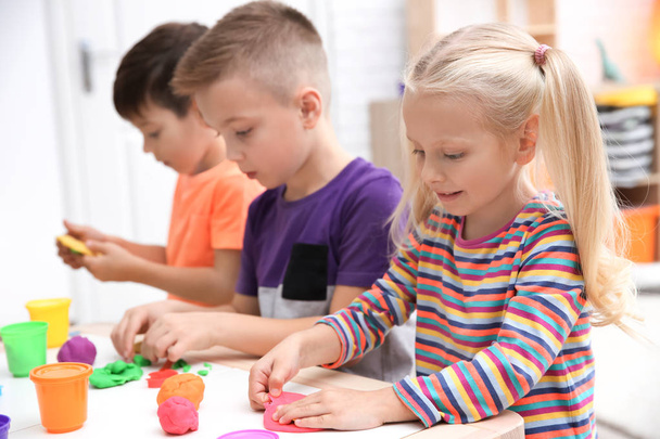 Małe dzieci zaangażowanych w playdough modelowania w przedszkolu - Zdjęcie, obraz