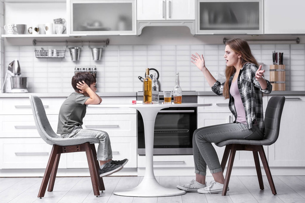 Drunk woman yelling at her son in kitchen - 写真・画像