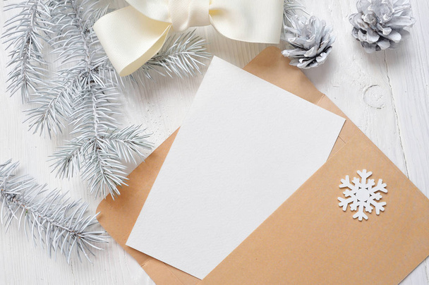 Рождественская открытка в конверте с белой ёлкой и конусом, плоский уголок на деревянном фоне, с местом для текста
 - Фото, изображение
